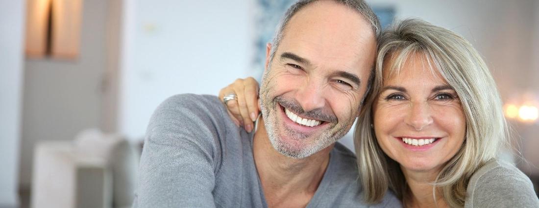 Couple smiling after getting dental implants in Hermitage, PA