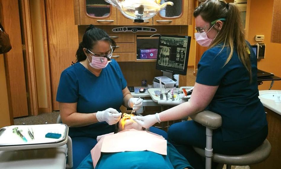 Dr Deanna Thomas and dental assistant performing dental exam in Hermitage PA